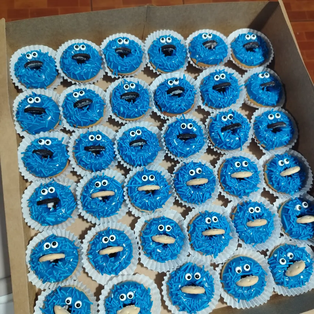 Caja con 40 mini donas azules decoradas como el Monstruo Come Galletas