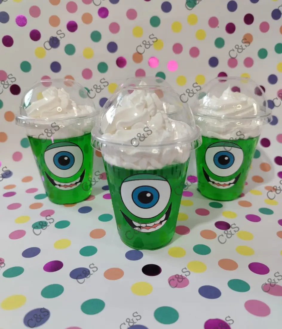 Tres vasos de gelatina verde con crema, decorados con la cara de Mike Wazowski